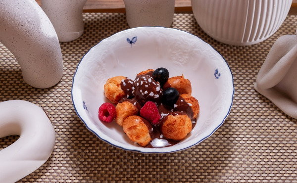 Профитроли с кремом, шоколадным соусом и ягодами